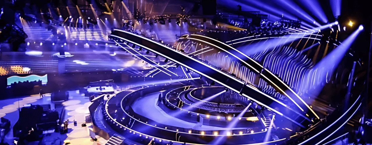 A large circular stage illuminated by vibrant lights, showcasing innovative and creative construction elements.